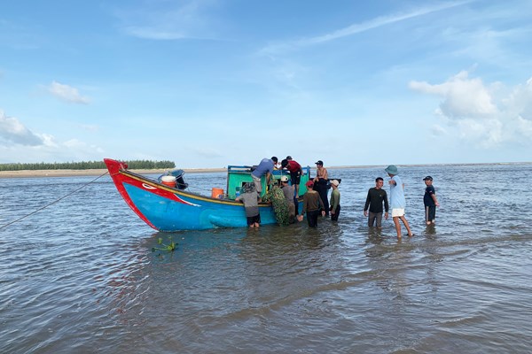 Quảng Bình: Bộ đội biên phòng cùng với người dân kéo thuyền nan bị nạn vào bờ - Anh 1