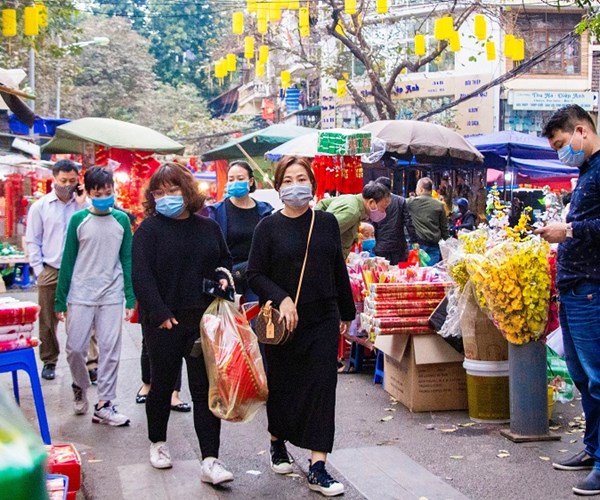 Hà Nội: Nhiều người dân đã ý thức đeo khẩu trang khi đi sắm Tết - Anh 6