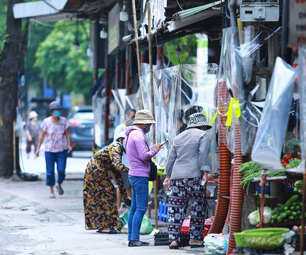 Khu chợ dân sinh đầu tiên ở Hà Nội quây ni-lon từng gian hàng để phòng dịch - Anh 2