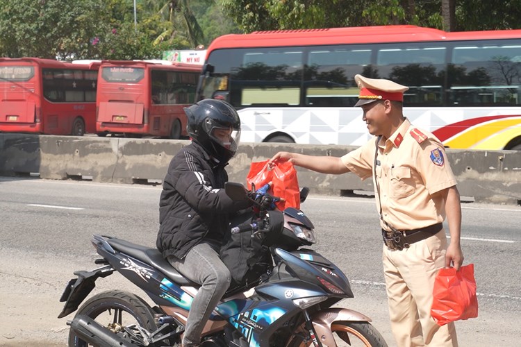 Cảnh sát giao thông Quảng Ngãi tặng quà, hỗ trợ người dân đi xe máy về quê ăn Tết - Anh 1